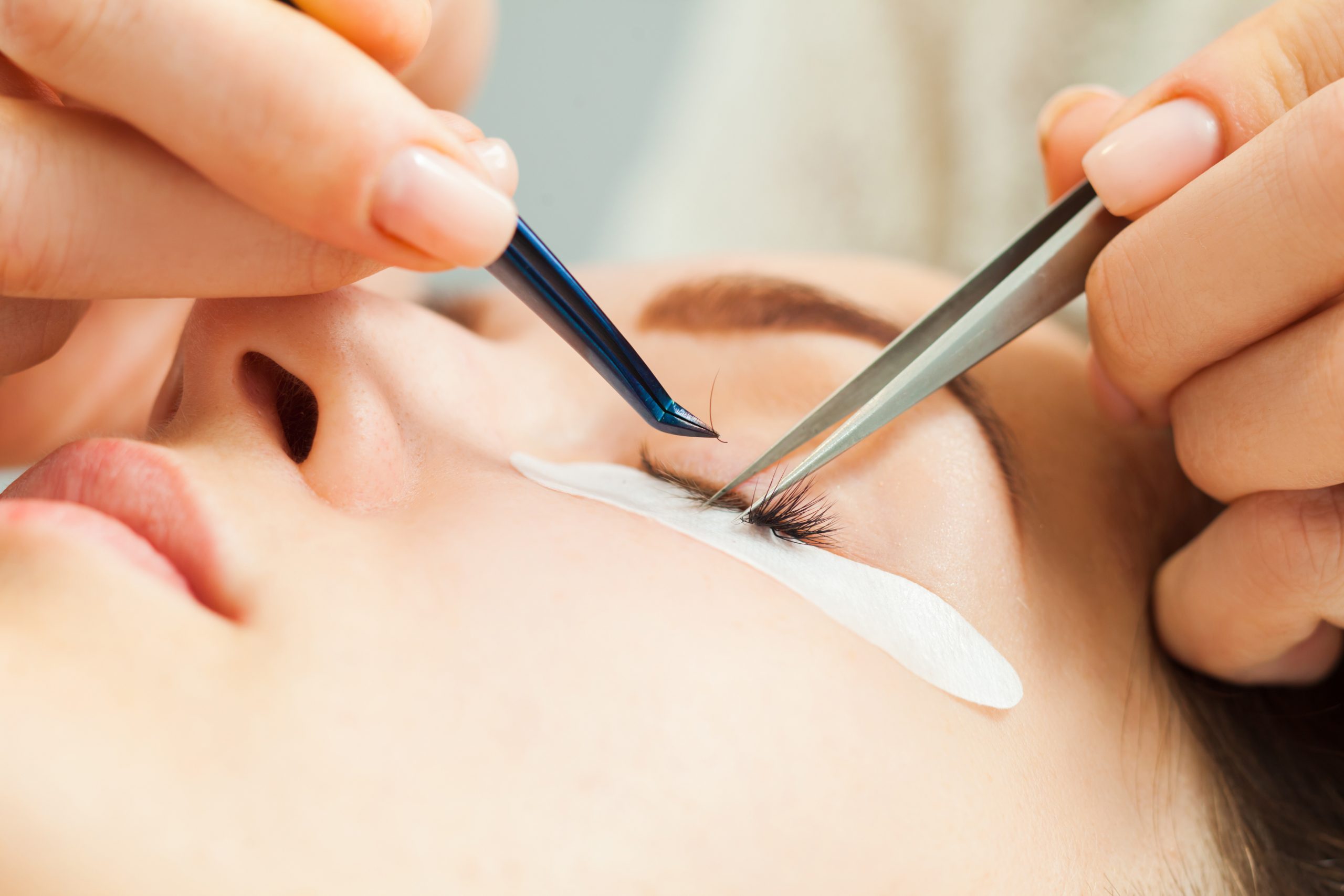 Woman with long eyelashes in a beauty salon during eyelash extension. Beauty concept
