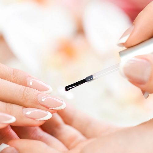 Beautician in luxury salon applying lacquer or varnish gel on nails.
Manicure nail paint with brush or artist polish modelation technique.